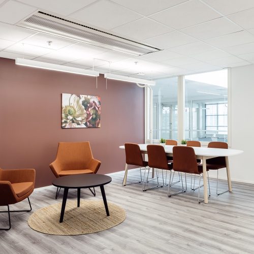 Toimistohotellin taukotilassa on ruokailupöytä sekä pieni pöytä nojatuoleineen.